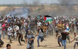 Palestinian demonstrators run for cover from tear gas fired by Israeli forces during a protest demanding the right to return to their homeland, at the Israel-Gaza border in the southern Gaza Strip